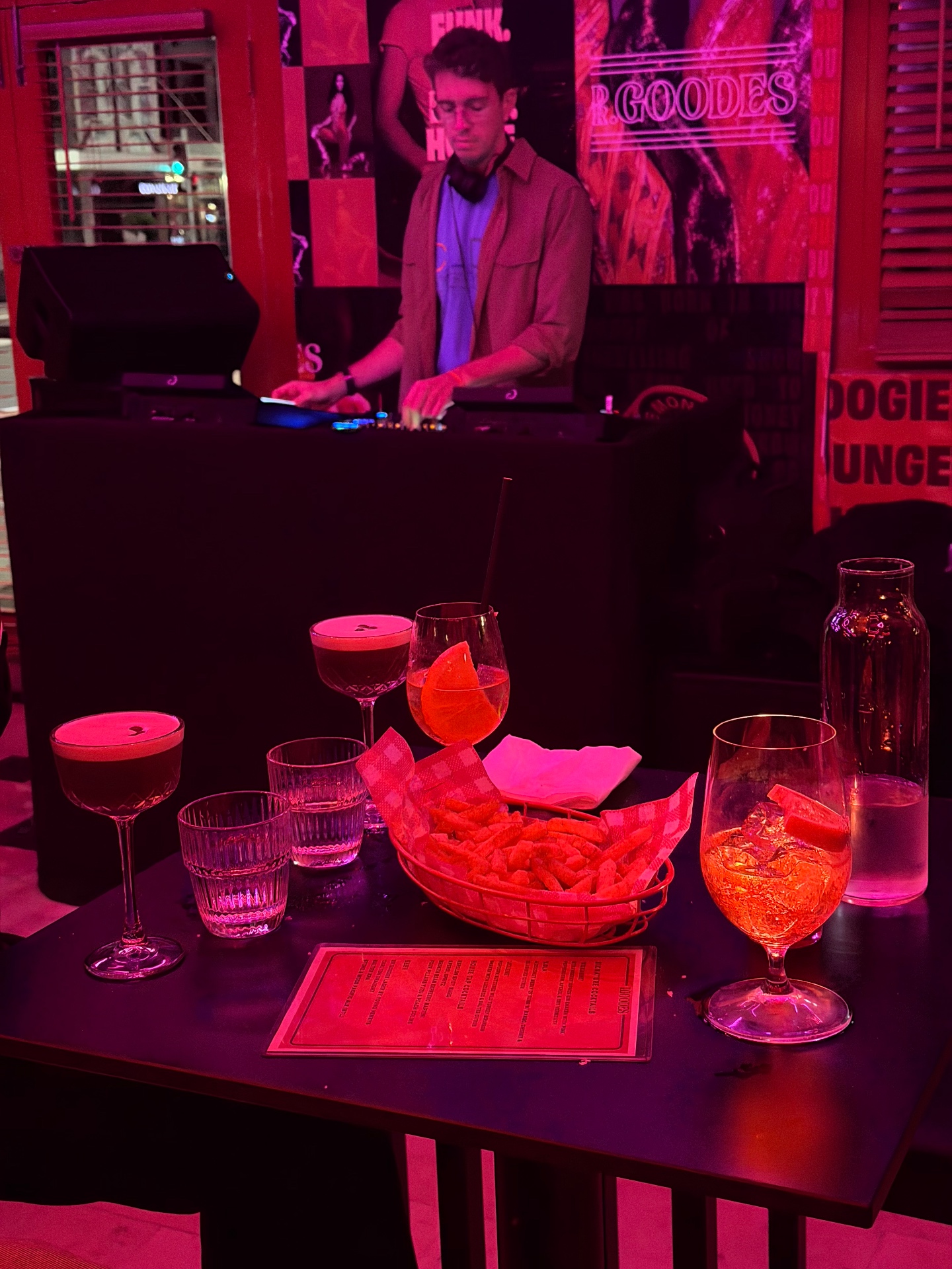 A table of signature cocktails and wood-fired pizza at DrGoodes Sydney — the Paddington boogie lounge where disco DJs, late-night snacks and craft drinks have made it one of the best bars in Sydney for dinner and dancing.