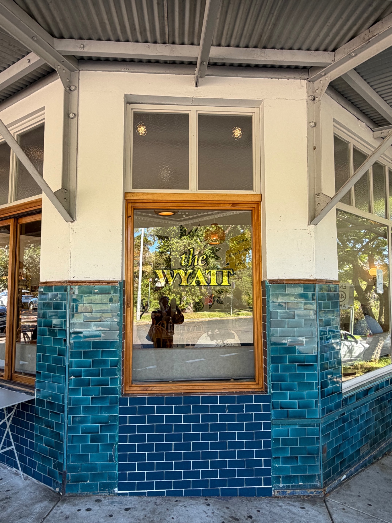 The exterior of The Wyatt cafe in Gordon, Sydney — a heritage corner shopfront with deep teal subway tiles, timber-framed windows and 'the WYATT' painted in gold on the glass.
