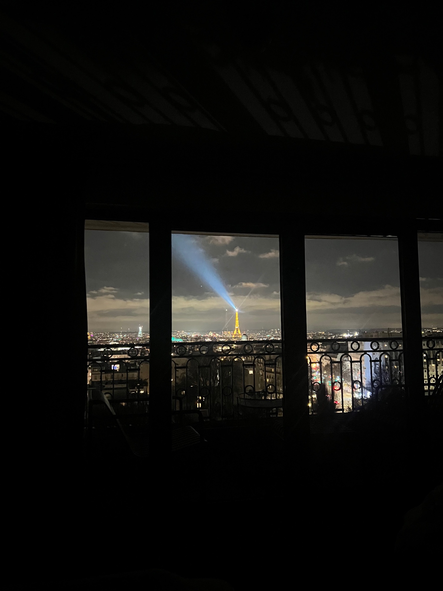 The night view from a balcony at Terrass Hotel in Montmartre, with the Eiffel Tower illuminated and sweeping over the Paris cityscape.